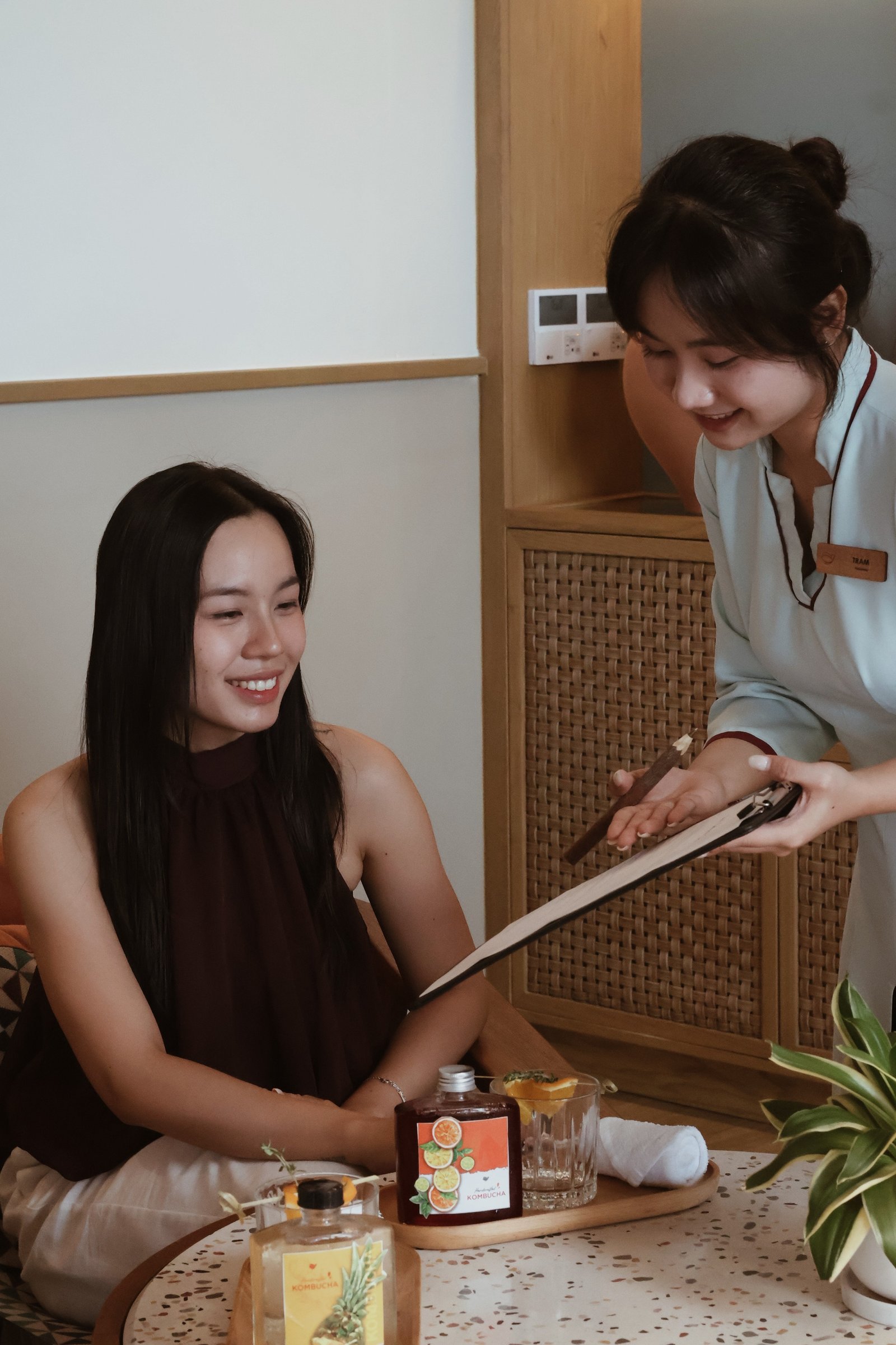 A smiling Hồi Retreat guest being welcomed and supported by Fusion staff on arrival
