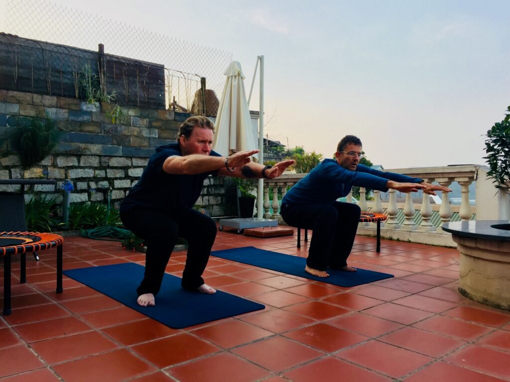 Two Vietnam Detox guests practising functional squats on a terrace