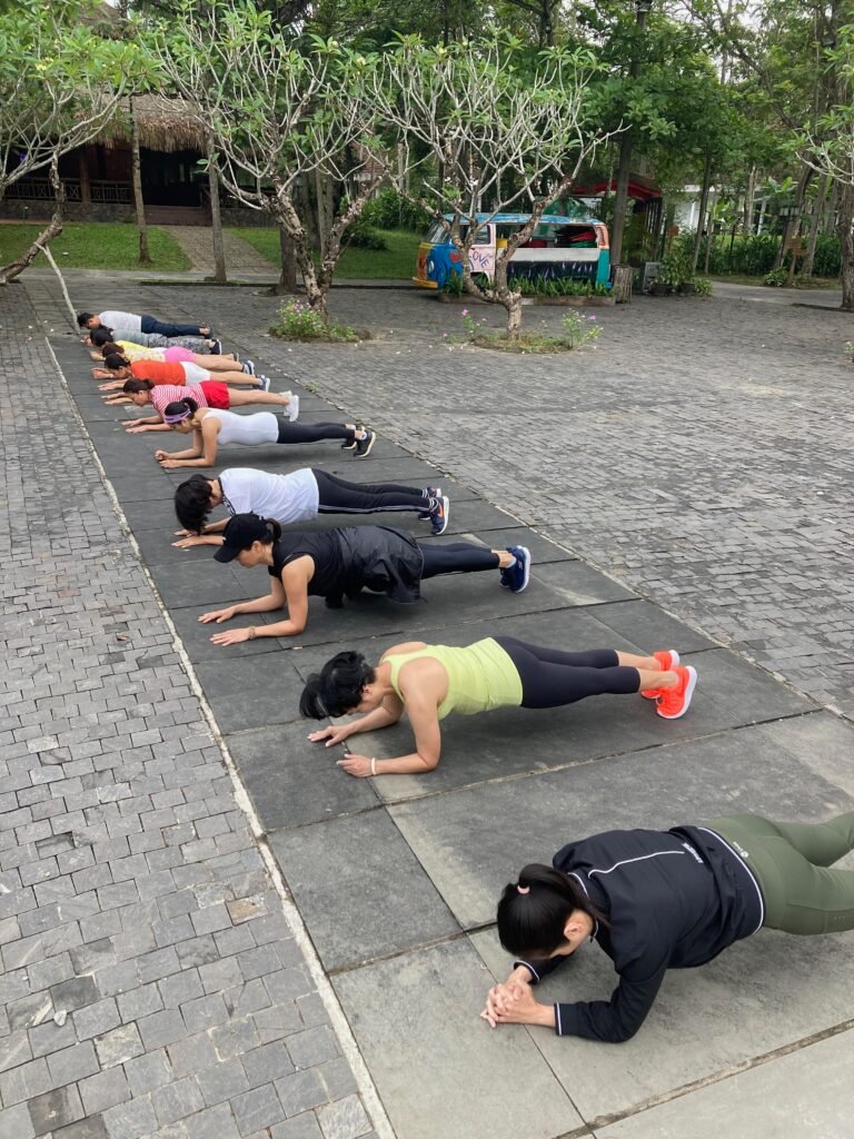 Vietnam Detox guests practising plank exercises outdoors
