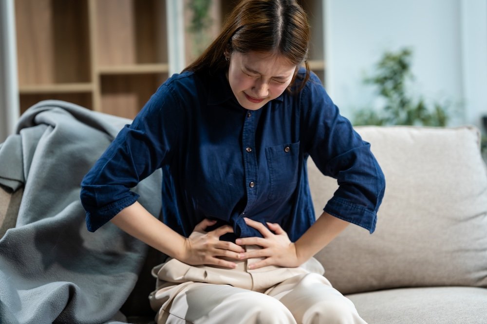 Woman holding her abdomen with bloating pain